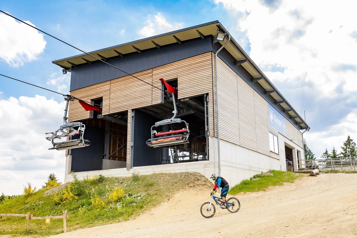 Liftstation mit Sessellift, davor ein Mountainbiker