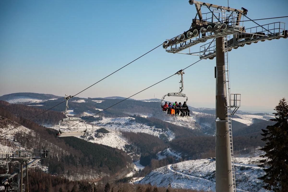 Sessellift über verschneiten Wäldern