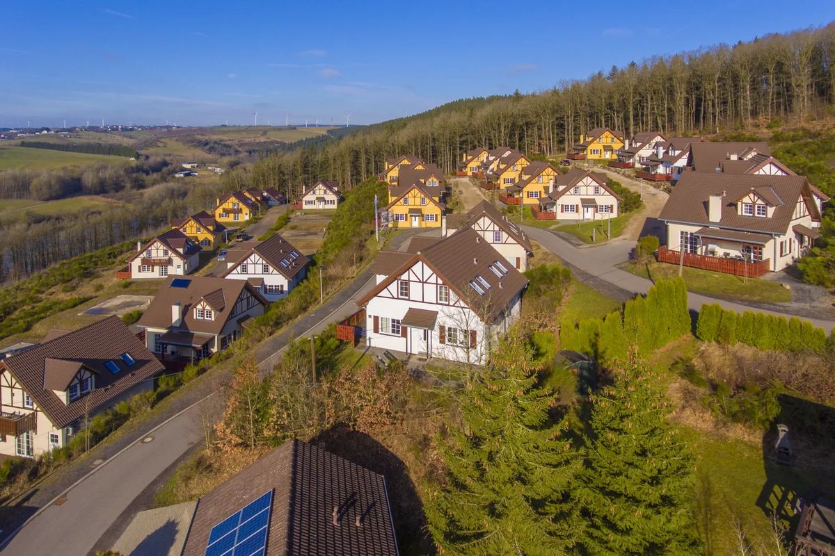 Luftbild: Ferienhäuser mit Gärten am Hang