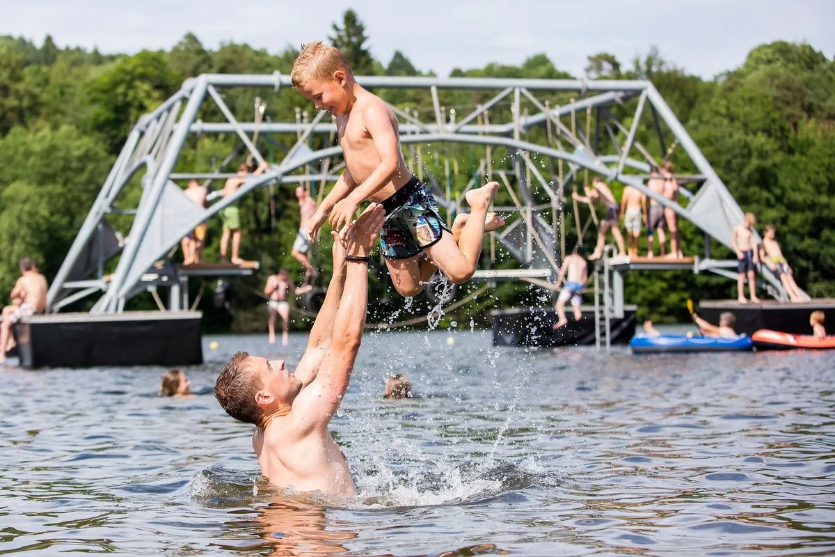 Familie badet im See an einem Badesteg