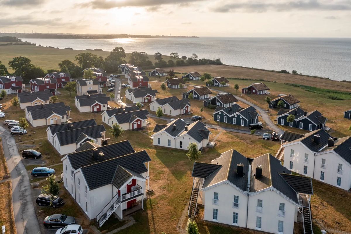 Luftbild: Holzhäuser an der Steilküste, dahinter die Ostsee