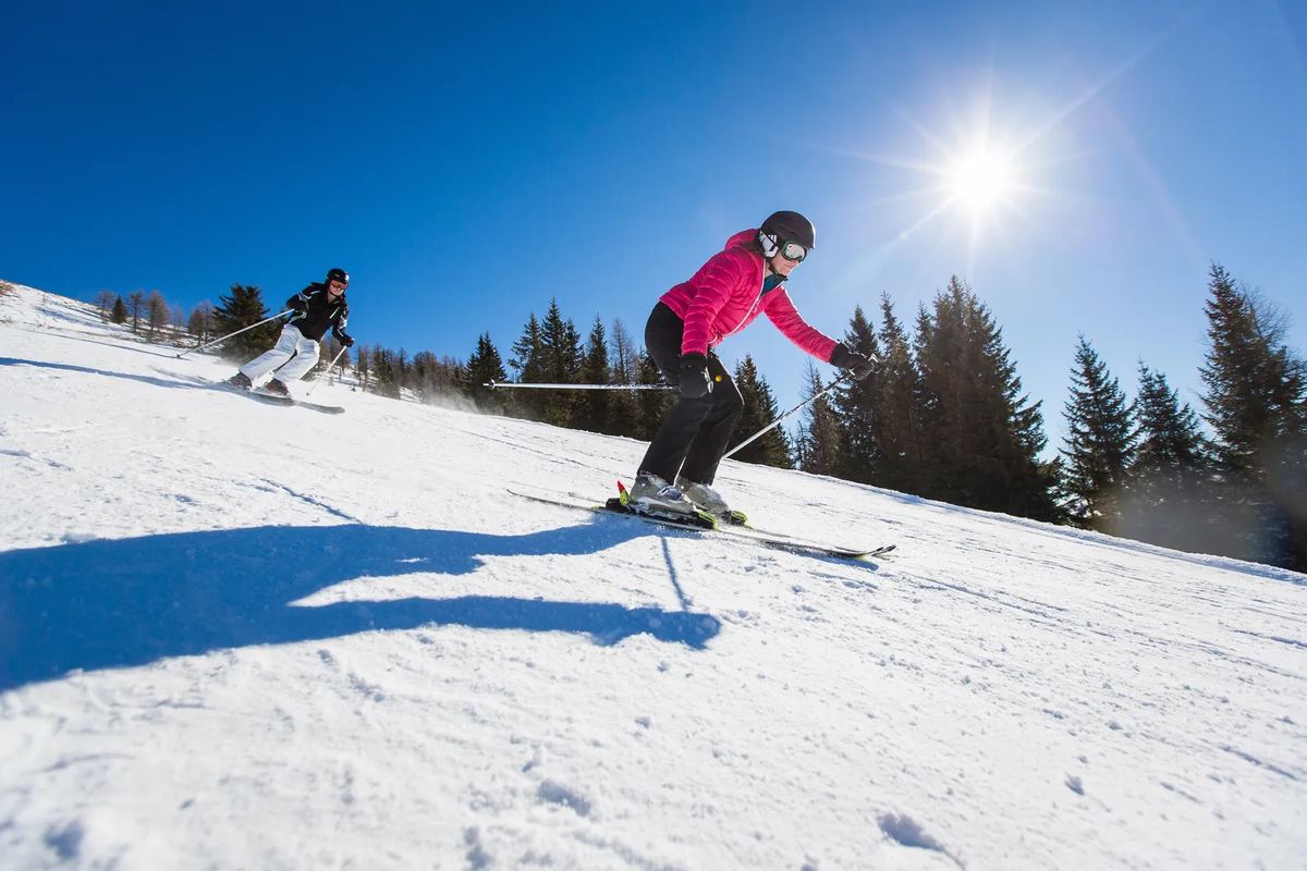 Skifahrerin auf einer Piste in der Sonne
