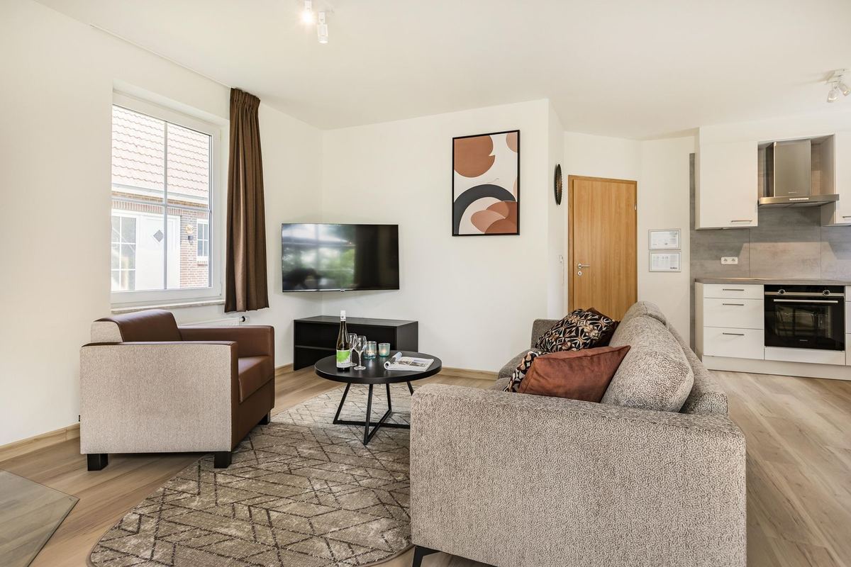Wohnzimmer mit Sofa und offener Küche