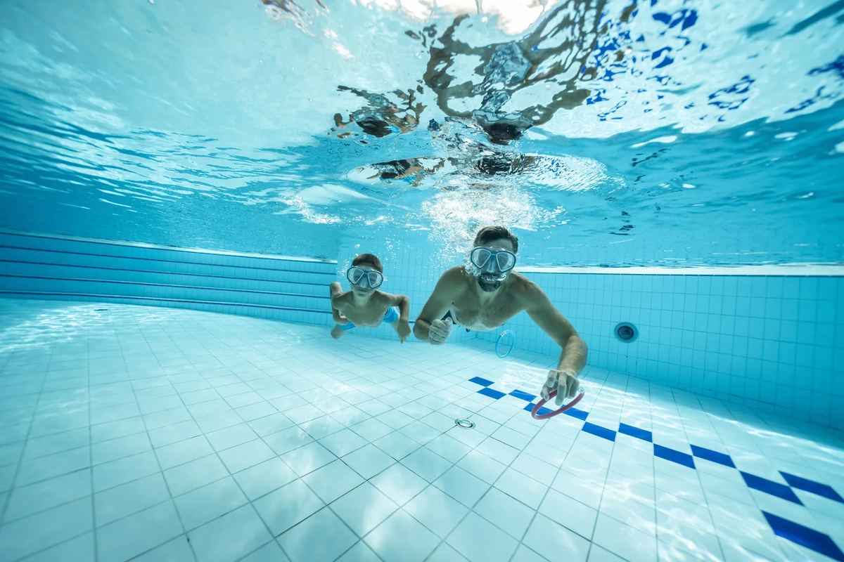 Unterwasserbild: Kinder tauchen im Schwimmbecken