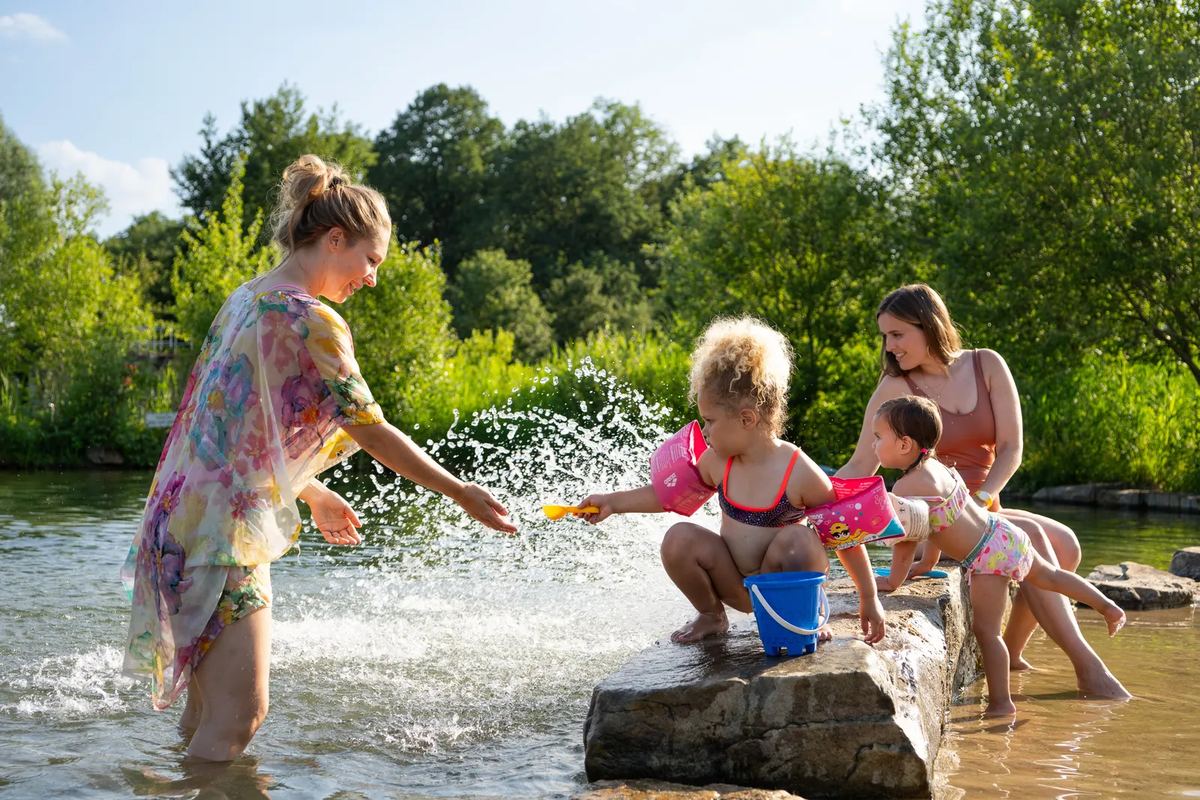 Familie spielt an einem Wasserlauf