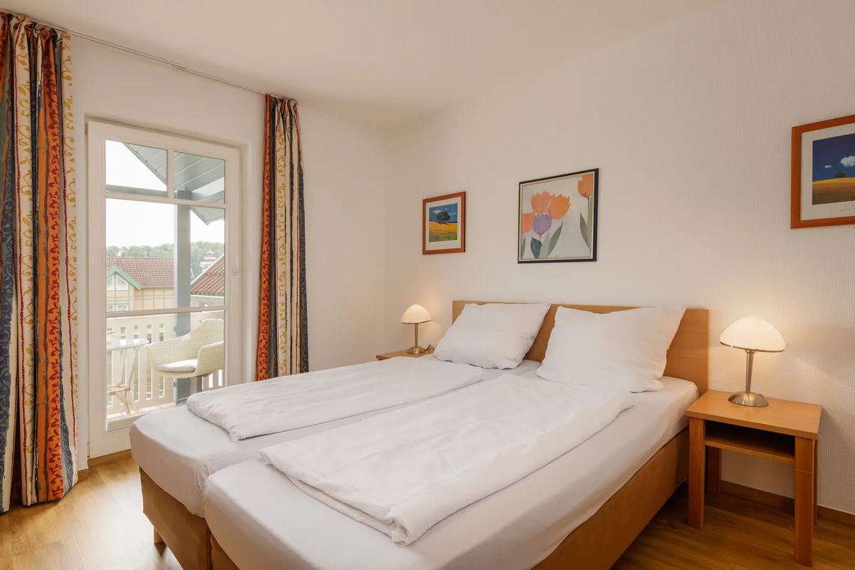 Schlafzimmer mit Doppelbett und Balkontür