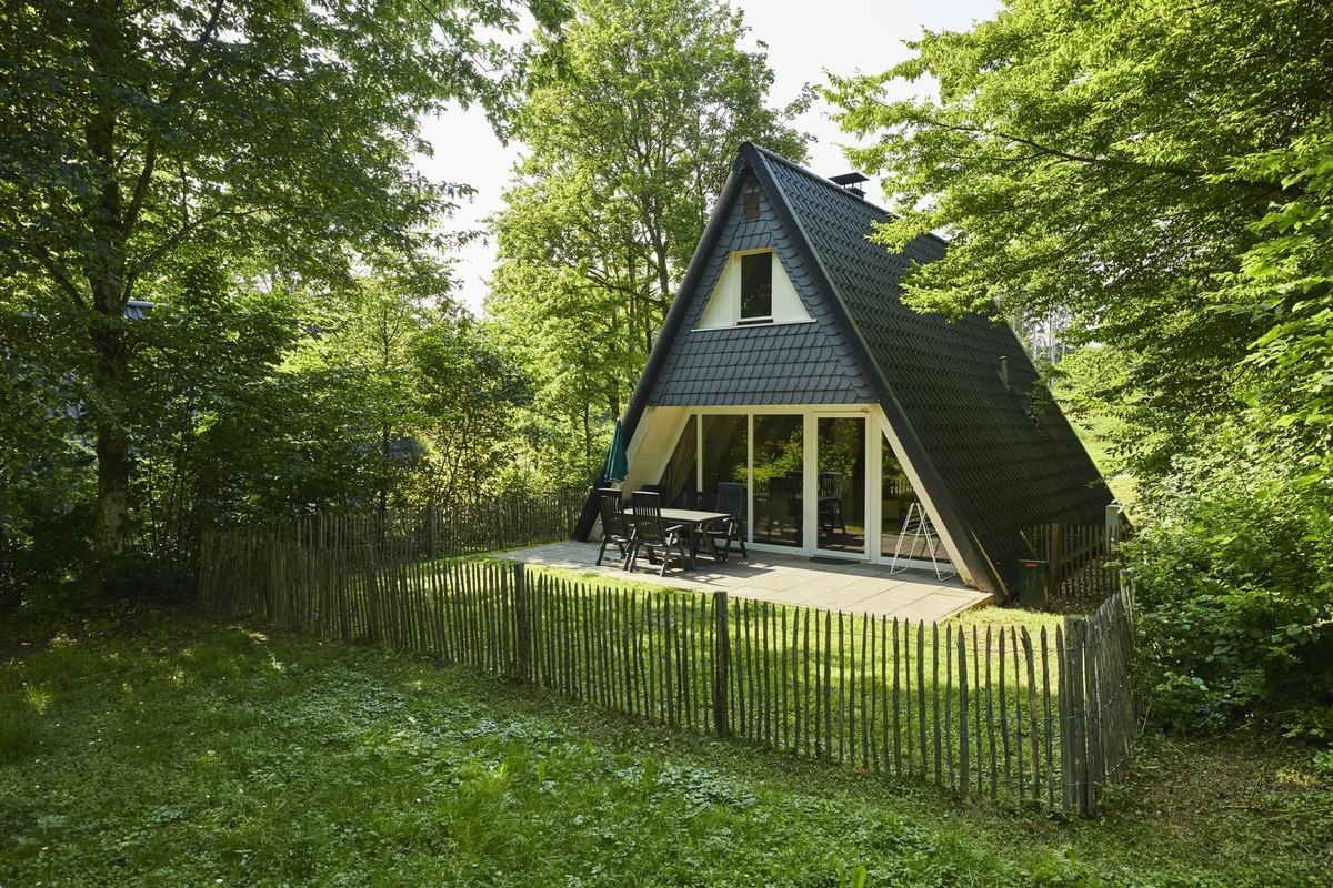Ferienhaus mit Spitzdach und Holzzaun