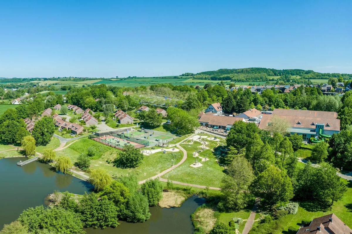 Luftbild: Park mit Teich, Wiesen und Ferienhäusern im Hügelland