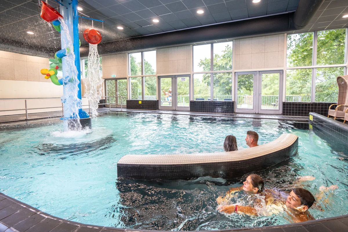 Becken mit Wasserfontäne und badenden Kindern