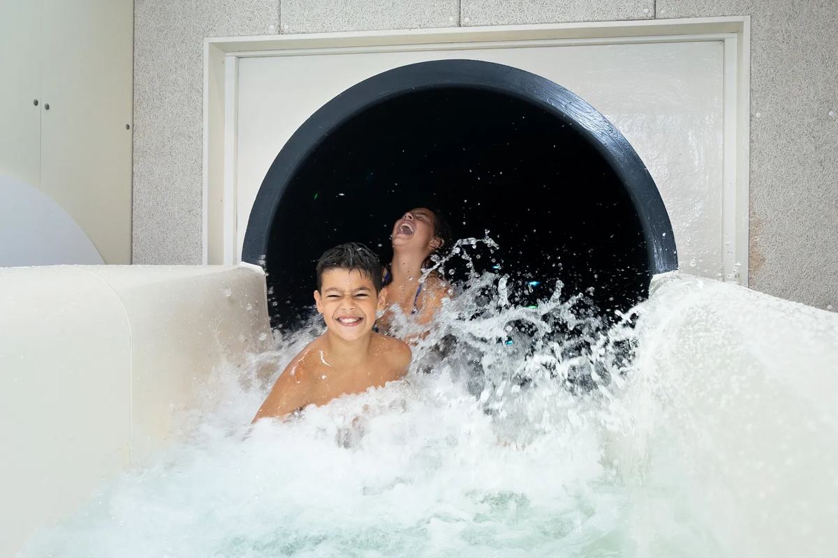 Kinder kommen aus einer Wasserrutsche