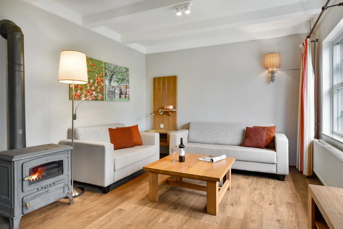 Wohnzimmer mit Holzofen und weißem Sofa