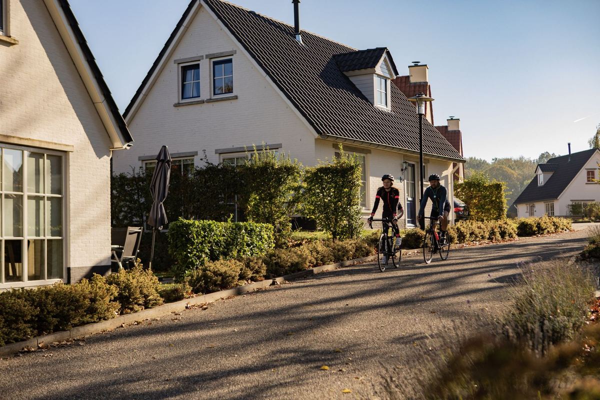Ferienhäuser an einer Straße, Radfahrer davor