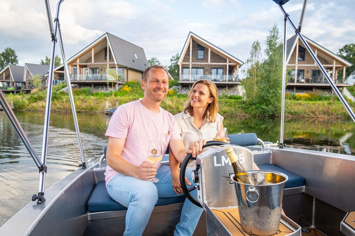 Paar in einem Boot vor Ferienhäusern