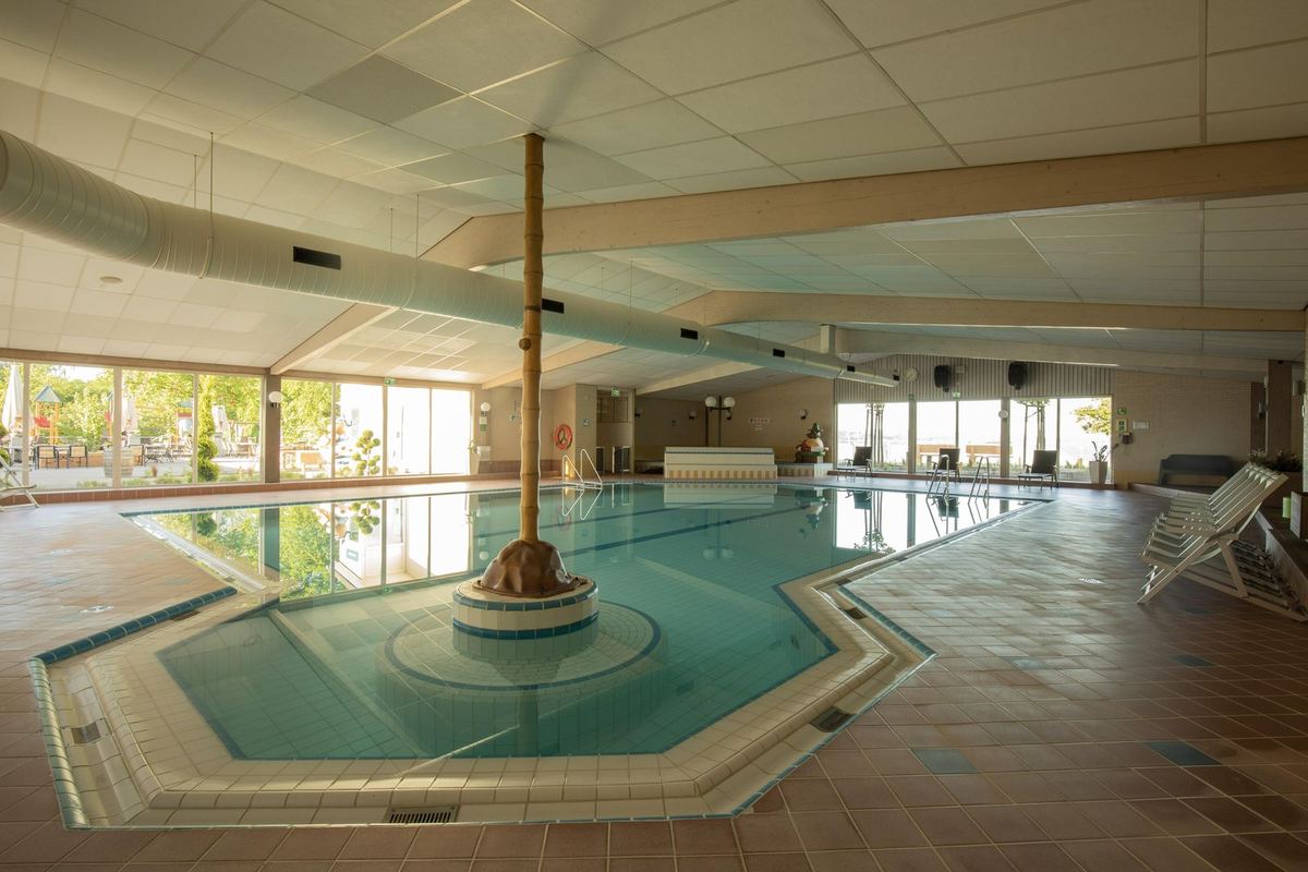 Hallenbad mit großem Becken und Fensterfront