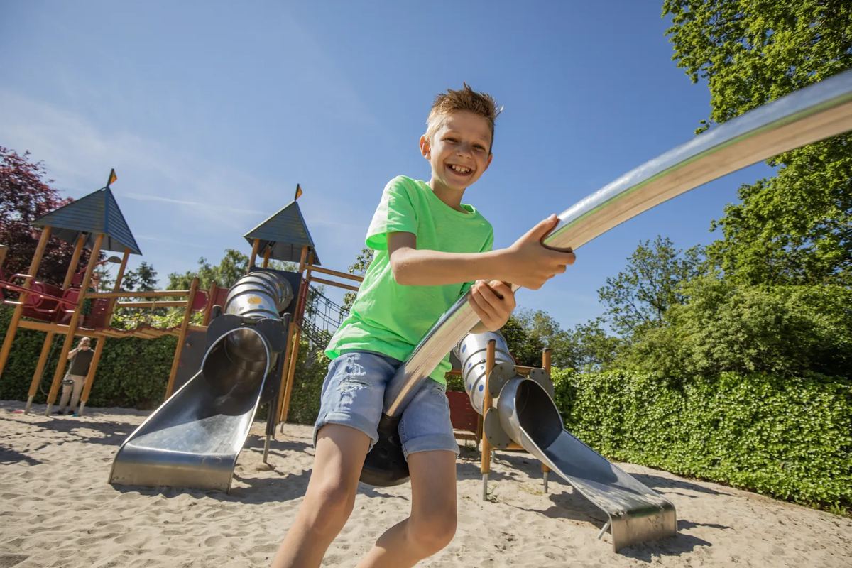 Junge auf einem Spielplatz mit Rutschen