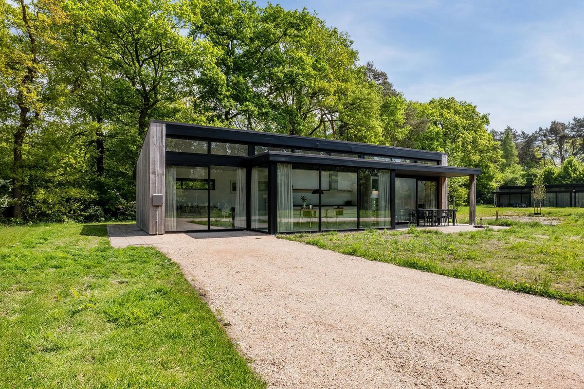 Flaches Ferienhaus mit Glasfront am Waldrand