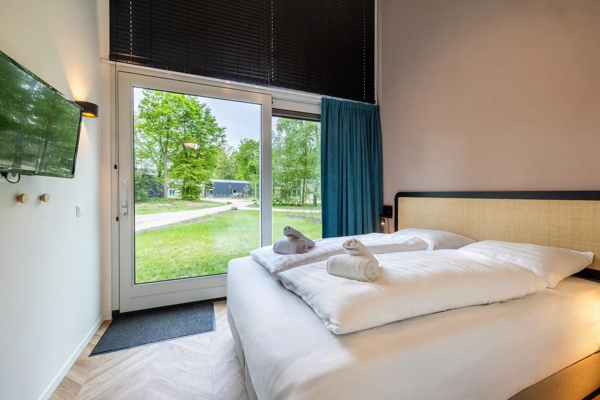 Schlafzimmer mit Fenstertür ins Grüne
