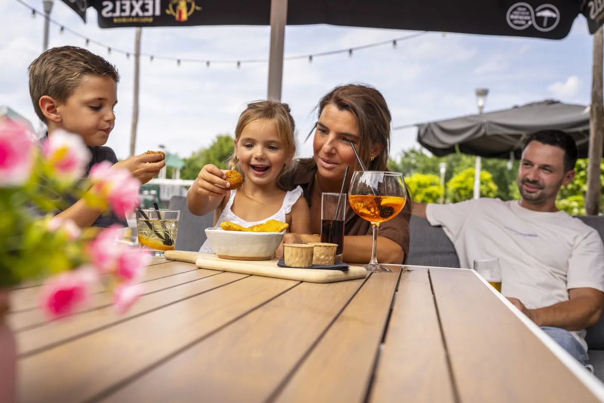 Familie auf einer Terrasse mit Snacks