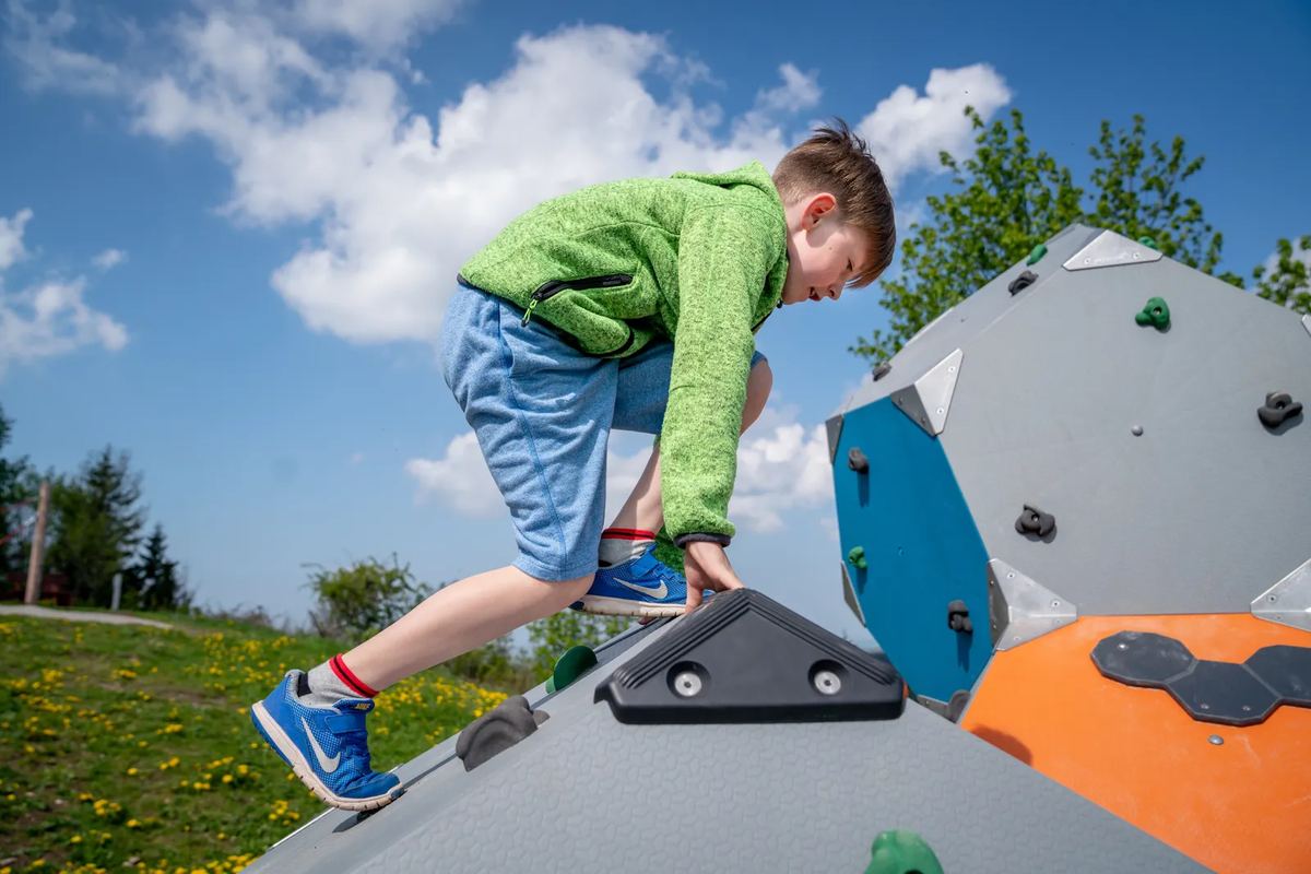 Junge klettert auf einem Kletterfelsen