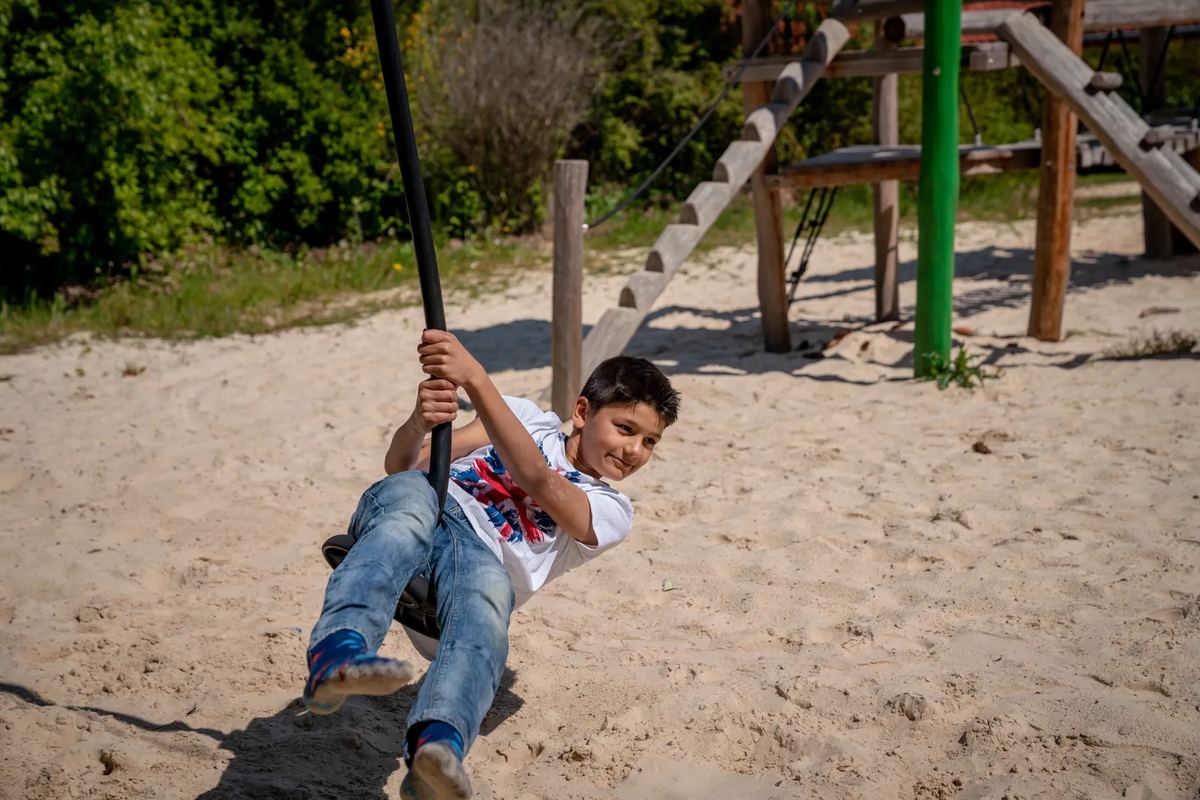 Junge an einer Seilbahn auf dem Spielplatz