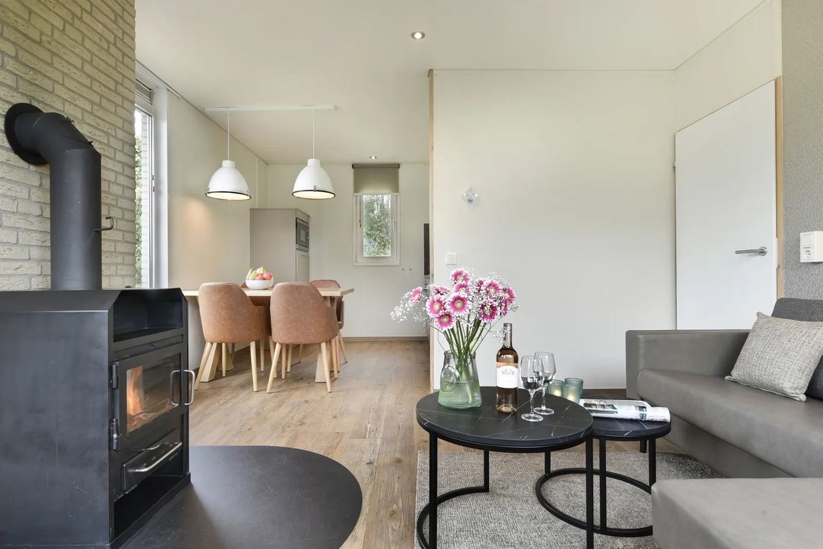 Wohnzimmer mit Holzofen, Sofa und Essbereich