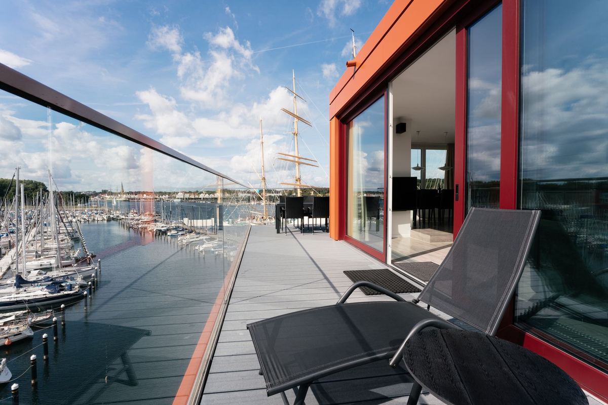 Terrasse mit Liegen und Blick auf Segelboote