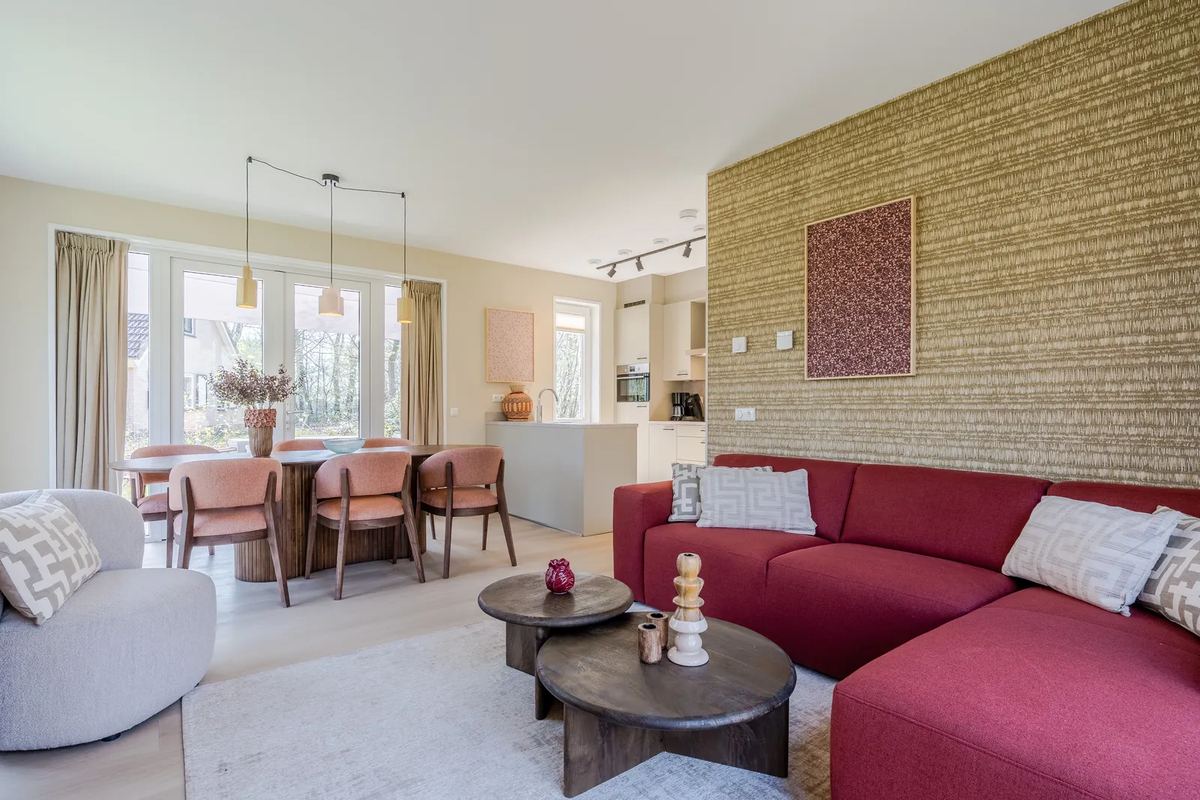 Wohnraum mit rotem Sofa und Ziegelwand