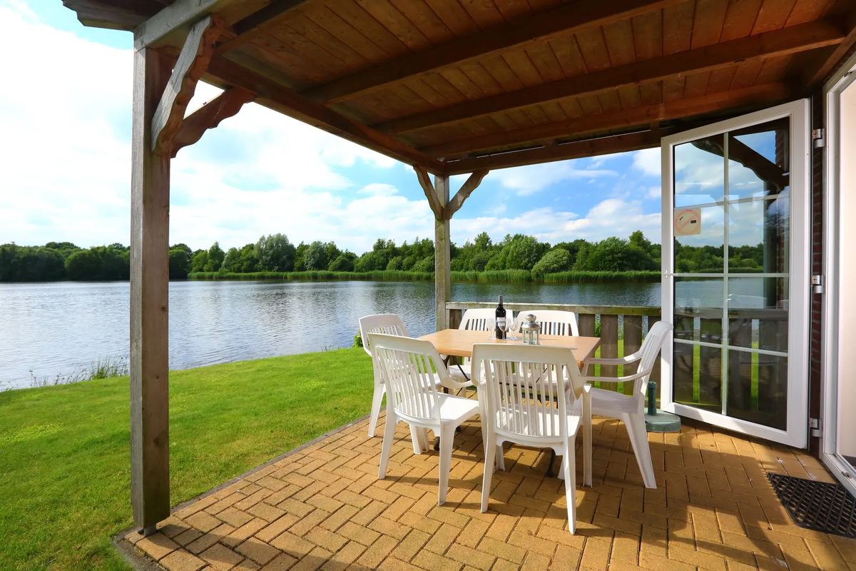 Überdachte Veranda mit Tisch am See