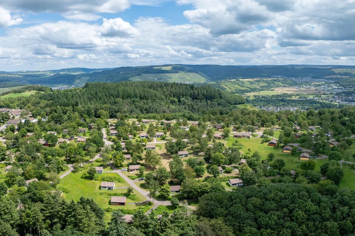 Luftbild: Ferienhäuser im Grünen über einem Tal