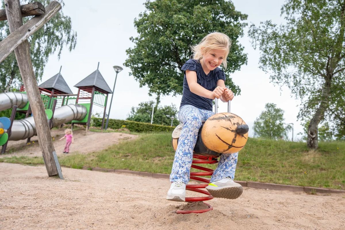 Mädchen auf einem Wipptier am Spielplatz