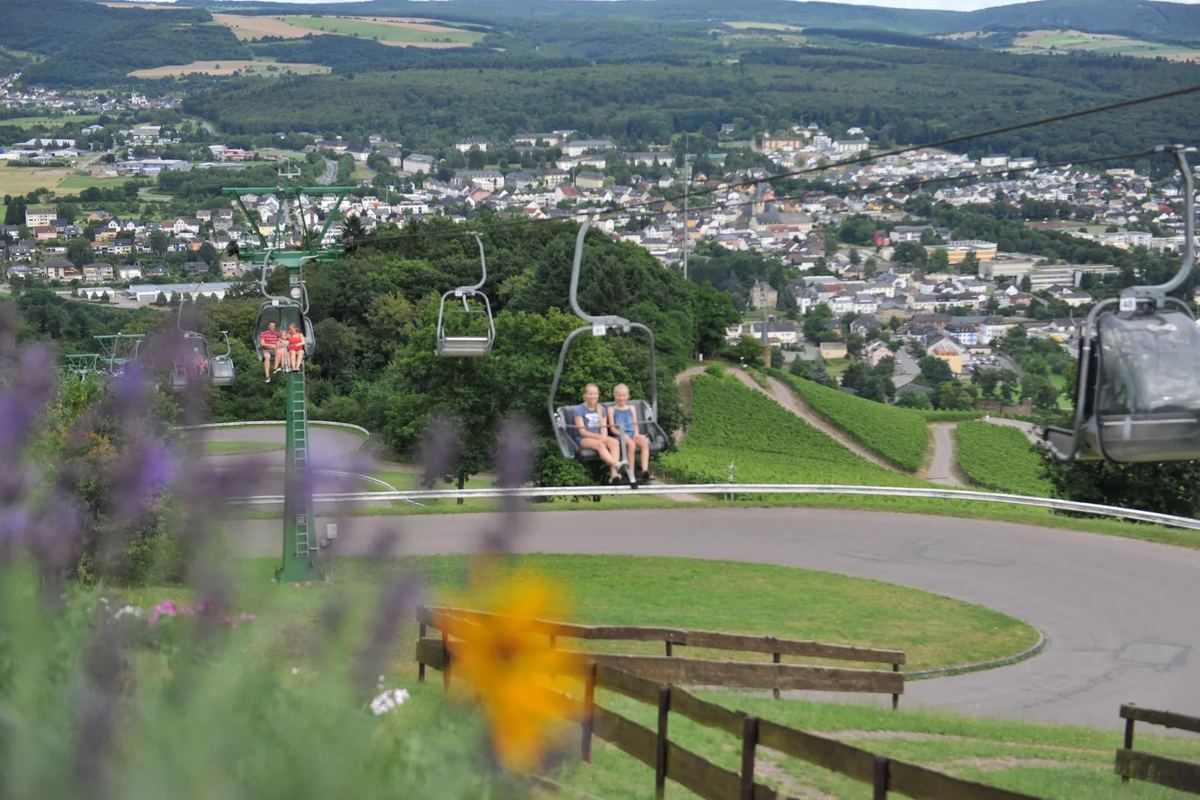 Sessellift über dem Hang, unten eine Stadt