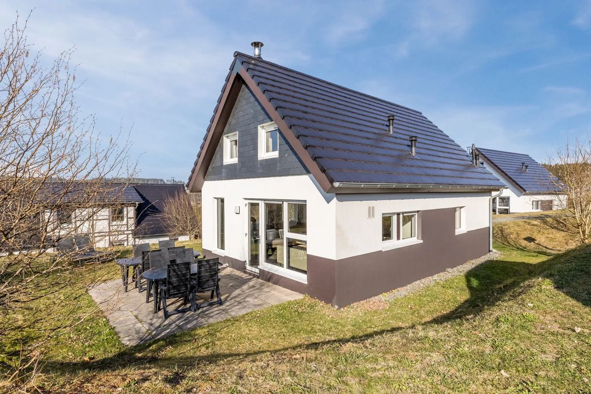 Ferienhaus mit dunklem Dach und Terrasse