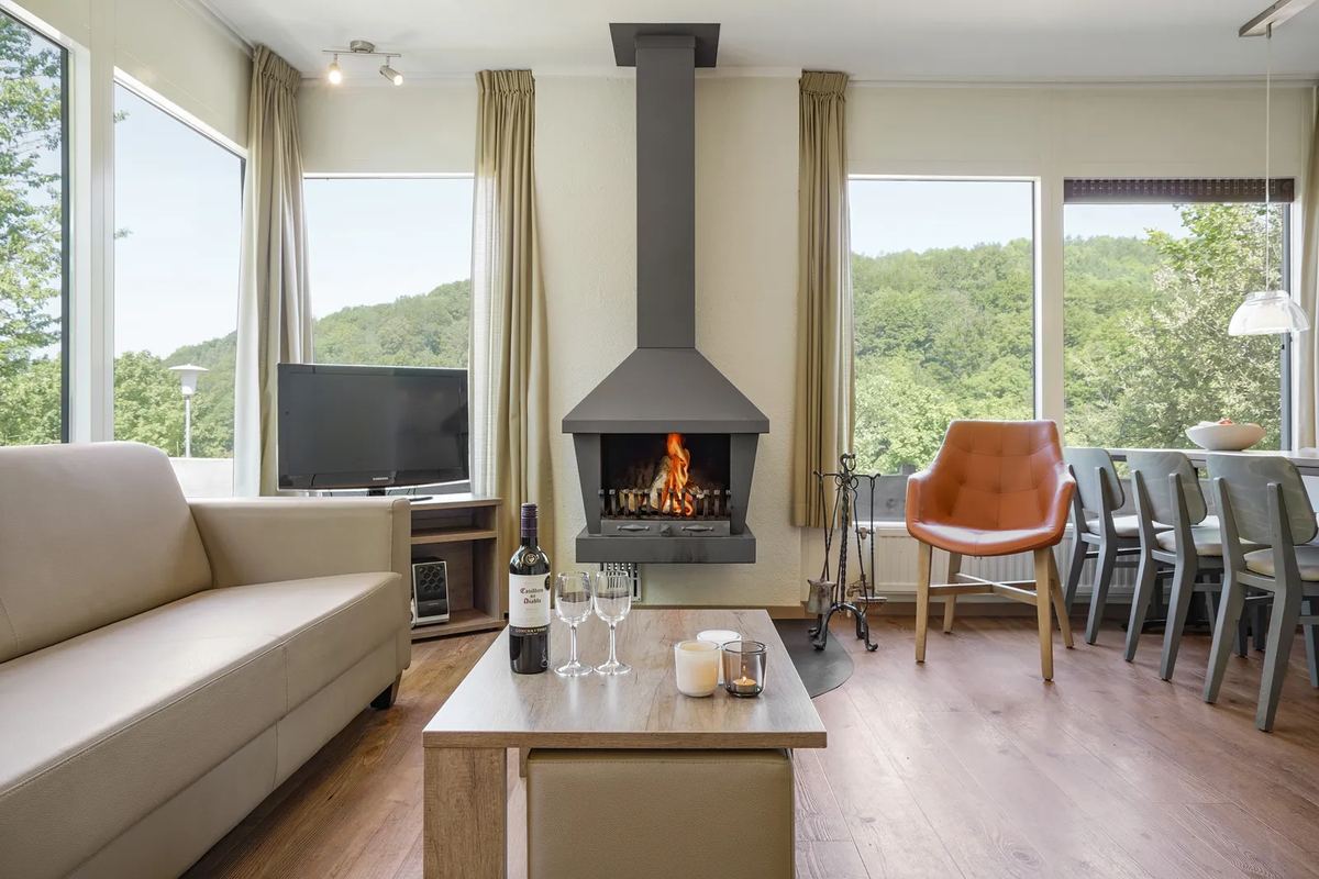 Wohnzimmer mit Kaminofen, Sofa und Essbereich