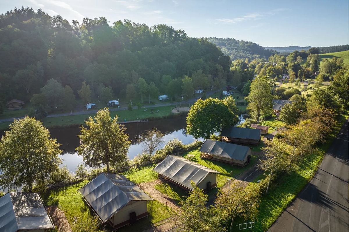 Zeltlodges am Wasser zwischen Bäumen